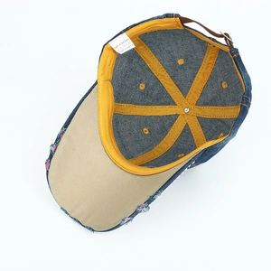 Détail d'une casquette denim effet vieilli avec étiquette 100% coton et boucle