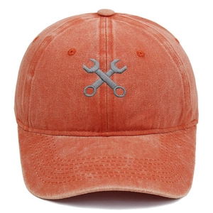 Broderie détaillée de clés croisées sur la texture d'une casquette en coton délavé