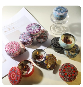 Top view of mandala tin scented soy candles with dried flowers and colorful boho prints
