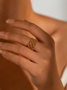 Detail shot of golden beaded hollow ring showing fine craftsmanship on finger