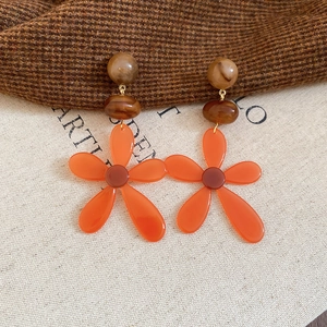 Detailed macro view of vintage resin earrings with amber flower charms and brown marble beads