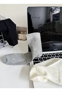 Detailed close-up of knitted ribbed cotton socks in black, grey, and white colors