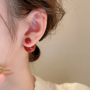 Nahaufnahme roter Doppelperlen-Ohrstecker mit minimalistischem geometrischem Design