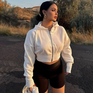 Close-up of white cropped zip-up hoodie featuring ribbed cuffs and soft cotton texture