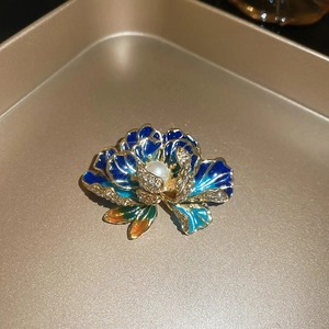 Detailed macro view of the blue enamel flower brooch with pearl inlay and crystals