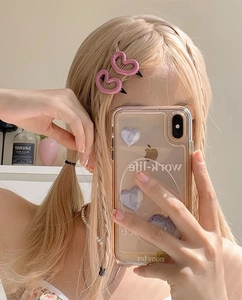 Gros plan de barrettes à cheveux roses en forme de cœur sur des cheveux blonds