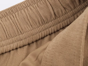 Gros plan du pantalon en velours côtelé marron montrant la taille élastique et le tissu