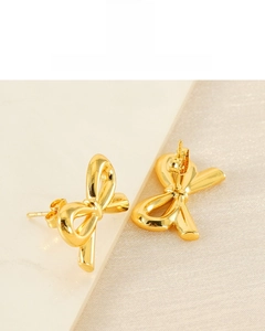 Macro shot of 18K gold plated bow-knot stud earrings showing polished metallic texture