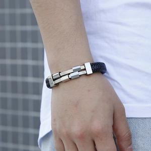 Close-up of black braided leather bracelet with punk style metal buckle on a male wrist