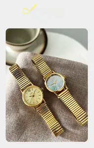 Detail view of gold vintage watches with mother of pearl dial and stretch metal bands