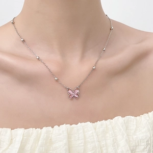 Silver strawberry crystal butterfly pendant necklace on female model with white blouse