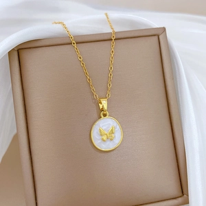 Macro detail of golden butterfly pendant with white oil drip inlay on titanium steel chain