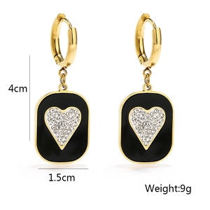 Detailed view of gold titanium earrings with black rectangle and crystal heart pendant