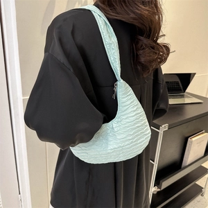 Minimalist light blue pleated shoulder bag with a cloud-like texture and zipper closure