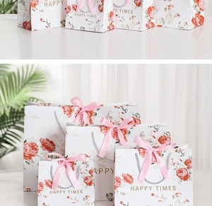 Detail of white marble texture gift bag with vintage red roses and pink ribbon bow