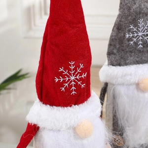Weihnachts-Zwergpuppen mit rot und grau bestickten Schneeflockenhüten zur Dekoration