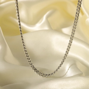 Silver stainless steel hip-hop chain necklace displayed on a beige silk background