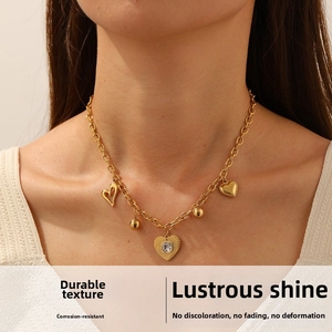 Détail du collier en acier inoxydable doré avec pendentifs en forme de cœur et cristaux