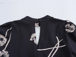 Detail of floral print blouse featuring a keyhole back, stand collar and button closure