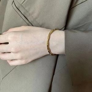 Elegant gold bamboo-shaped titanium steel bracelet for women shown on a model's wrist