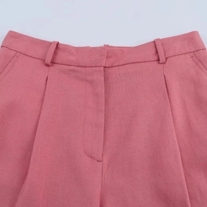 Close-up of pink linen-blend fabric showing detailed waistband stitching and texture