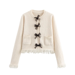 Chic cream knit cardigan with round neck, black bow accents and fringe detail edges