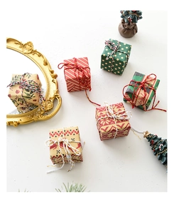 Detailed view of six miniature Christmas gift boxes with various festive patterns and twine bows