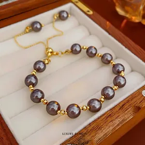 French retro pearl bracelet with gold beads and adjustable chain on a beige jewelry tray