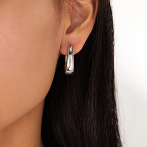 Close-up of a minimalist silver U-shaped earring shown worn for scale and shine