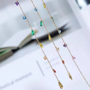 Minimalist gold titanium necklace with colorful zircon stones shown from a close-up angle