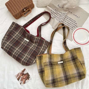 Close-up of vintage plaid tote bags in brown and yellow tones with textured fabric