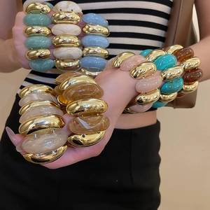 Detail of chunky acrylic marble texture bangles with high-shine metallic segments