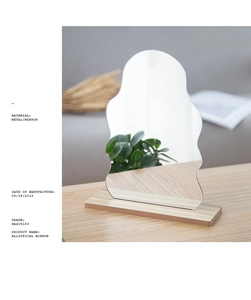 Detail of wavy acrylic makeup mirror featuring a solid wooden base for desktop use