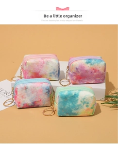 Detailed view of four mini tie-dye plush storage pouches with golden zipper and keychains