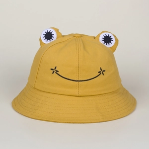 Close-up of a yellow frog bucket hat with 3D eyes and embroidered smiley face detail