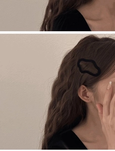 Detail of a black flocked irregular geometric hair clip styled on a woman's side hair
