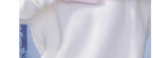Detailed macro view of white knit fabric with soft pink faux fur trim on winter headwear
