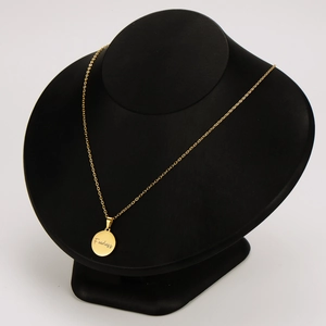 Collana in acciaio inossidabile dorato con ciondolo Fearless su espositore a busto nero