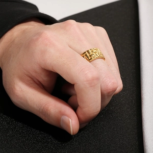 Detailed view of wide gold-toned stainless steel ring with woven embossed texture