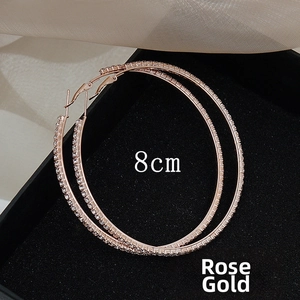 Detail view of 8cm rose gold hoop earrings with sparkling rhinestones in a gift box