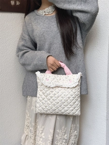 Detail of quilted floral laptop bag with lace trim and pink handles for 11 inch devices