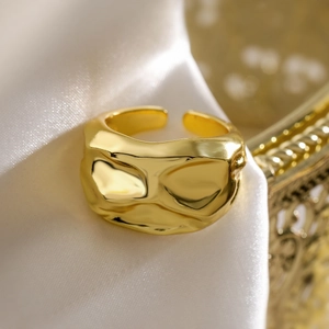 Polished gold irregular molten texture open ring with fluid aesthetic on silk backdrop