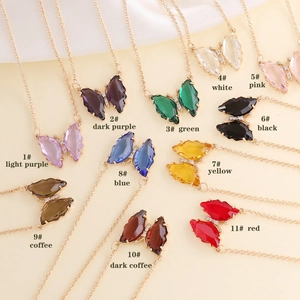 Minimalist butterfly pendant necklaces in multiple colors displayed on a beige background