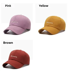 Detail of embroidered Memorie logo on cotton twill caps in pink, yellow and brown
