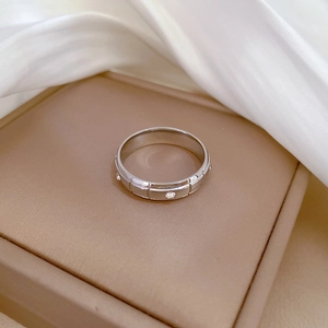 Detail of silver geometric titanium ring with rectangle grooves and small sparkling crystals