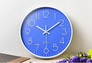 Detail of a 14-inch blue wall clock with 3D white numerals and quartz movement