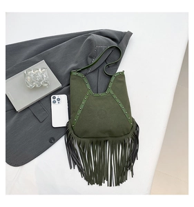 Detail of dark green suede shoulder bag with bohemian fringe and metallic rivets