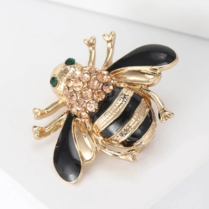 Detailed close-up of a bee brooch with champagne rhinestones and black enamel wings