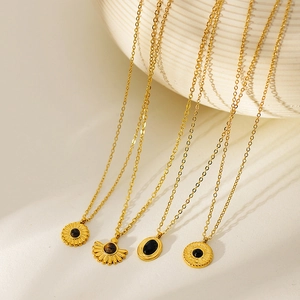 Detail of four vintage gold sunflower and natural stone pendants on O-chain necklaces
