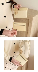 Detailed view of cream textured coin purse and striped card holder with gold keychain